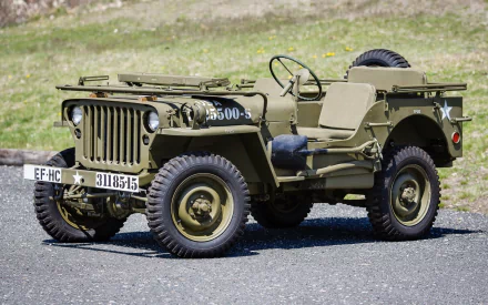 HD desktop wallpaper featuring a classic military Willys MB jeep parked on a paved surface with a grassy background.