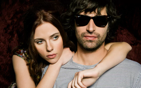 A 4K Ultra HD PC desktop wallpaper featuring a celebrity woman with auburn hair and a man wearing dark sunglasses against a dark, textured background.