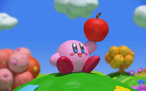 HD desktop wallpaper of Kirby from 'Kirby and the Rainbow Curse' with a red apple on a colorful backdrop.