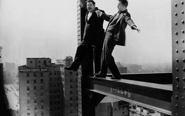 Black-and-white 4K Ultra HD PC desktop wallpaper of two men in classic comic-duo attire teetering on a steel beam high above a city skyline.