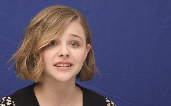 Chloë Grace Moretz presents a captivating expression against a blue background, featured as a 4K Ultra HD PC desktop wallpaper and background.