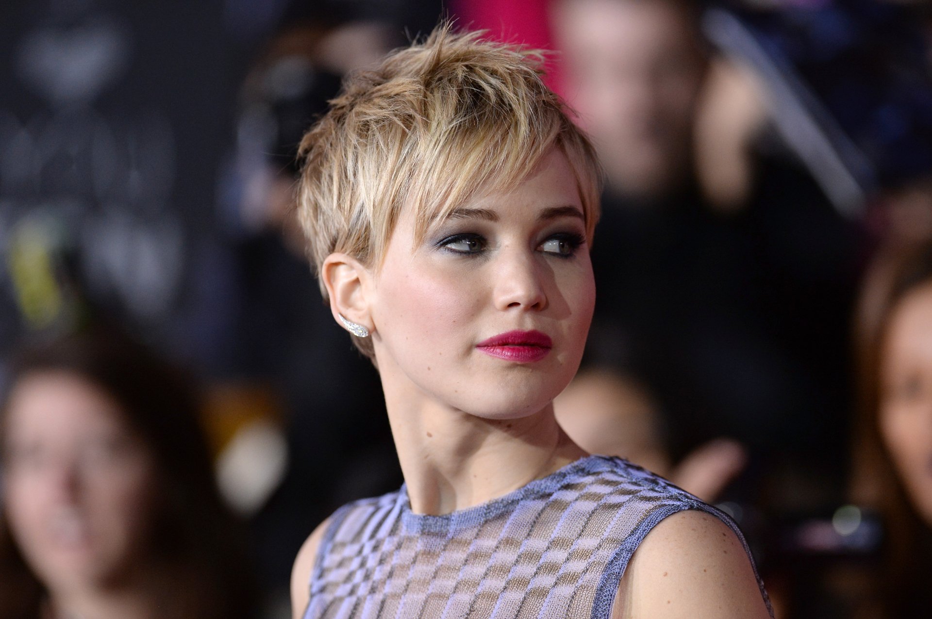 HD PC desktop wallpaper featuring a close-up of celebrity Jennifer Lawrence with short blonde hair and a patterned top at a public event.