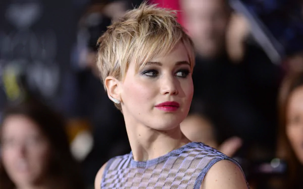 HD PC desktop wallpaper featuring a close-up of celebrity Jennifer Lawrence with short blonde hair and a patterned top at a public event.