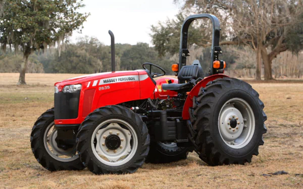 A vibrant Massey Ferguson tractor stands prominently on open terrain, showcasing its rugged design and sturdy tires. This HD image serves as an eye-catching desktop wallpaper.