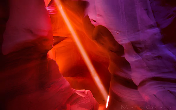 Sunbeam piercing red-orange sandstone walls of Antelope Canyon in Arizona, desert canyon layers and purple shadows — HD PC desktop wallpaper and background.