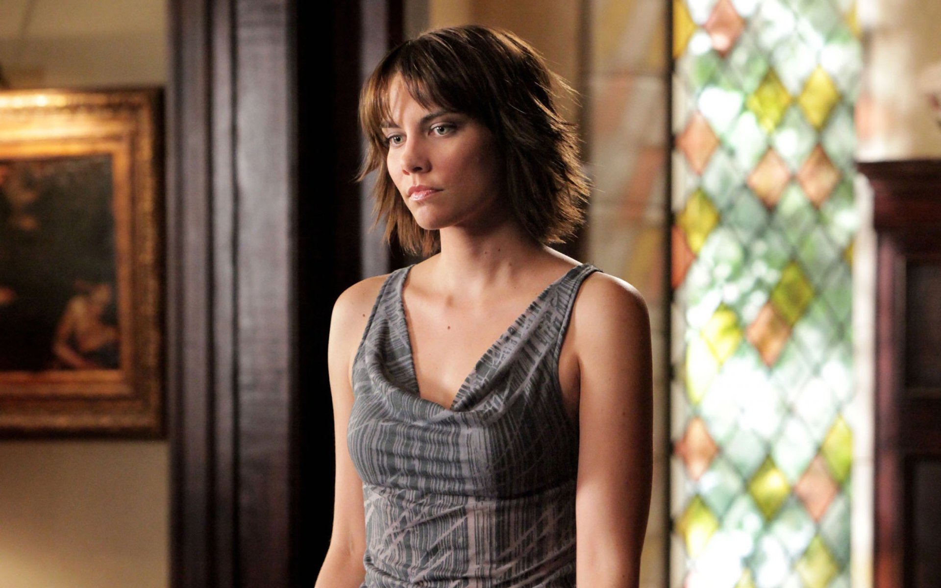 A character from The Vampire Diaries stands contemplatively, framed by a colorful stained glass window in this HD desktop wallpaper and background.