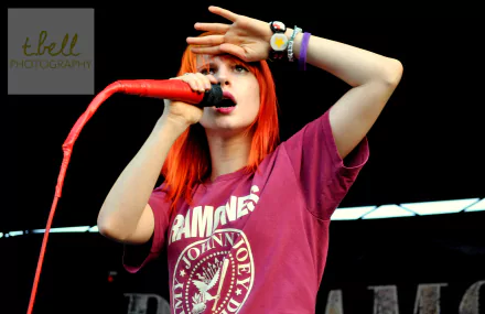 4K Ultra HD PC wallpaper featuring Hayley Williams singing passionately into a red microphone, captured in a vibrant live music performance moment.