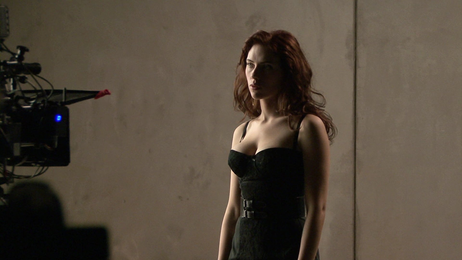 Scarlett Johansson poses confidently in a stylish black outfit, captured during a film shoot. This HD desktop wallpaper exudes a vibrant and cinematic atmosphere.