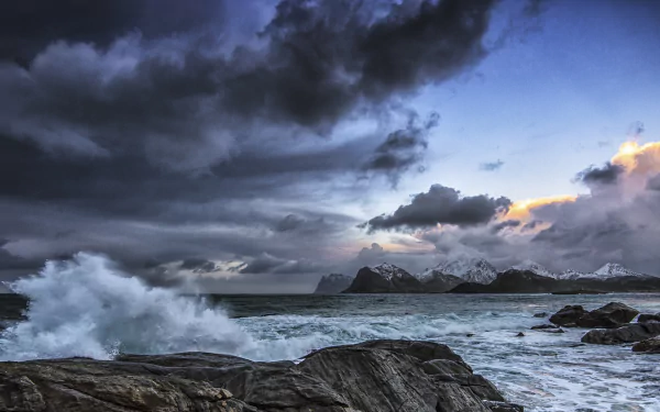 Dramatic seashore view of the Lofoten Islands in Norway, featuring rugged coastline, crashing waves, and a moody sky, captured in stunning HD for a nature-inspired desktop background.