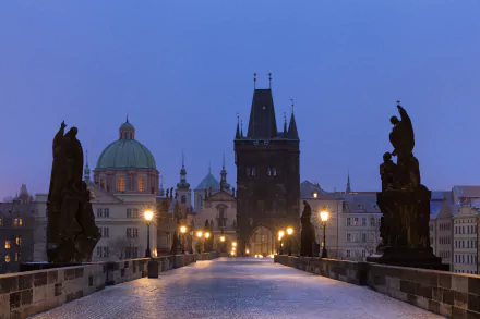The Charles Bridge in Prague, Czech Republic, features historic statues lining the man-made stone bridge at dusk, captured in stunning 4K Ultra HD detail.