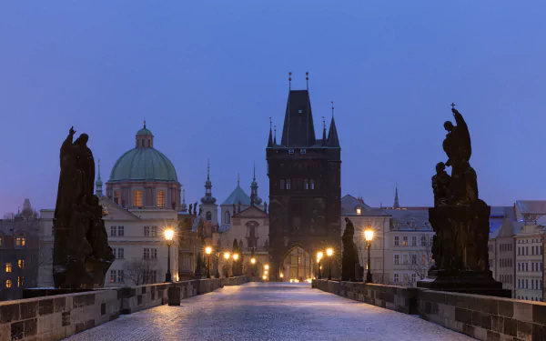 The Charles Bridge in Prague, Czech Republic, features historic statues lining the man-made stone bridge at dusk, captured in stunning 4K Ultra HD detail.