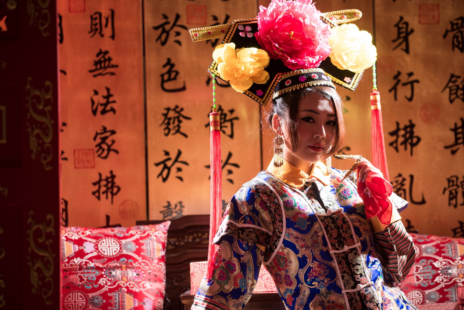 A Taiwanese woman dressed in traditional Chinese costume, inspired by Qián Fūrén, poses gracefully against a backdrop of classic calligraphy.