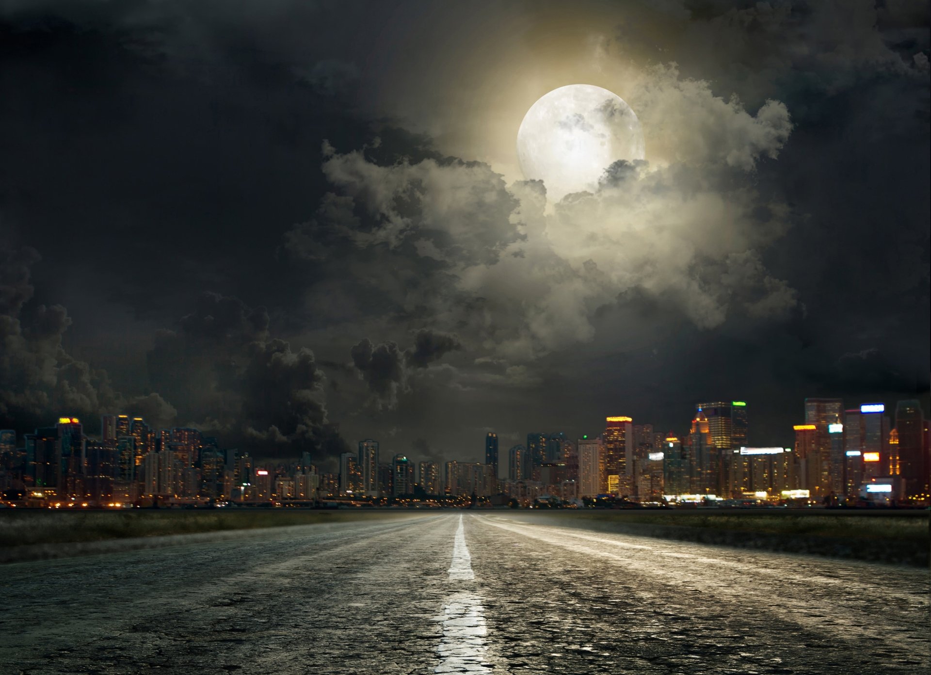 4K Ultra HD wallpaper showing a man-made road leading toward a brightly lit city skyline under a large, glowing moon with dramatic night clouds.