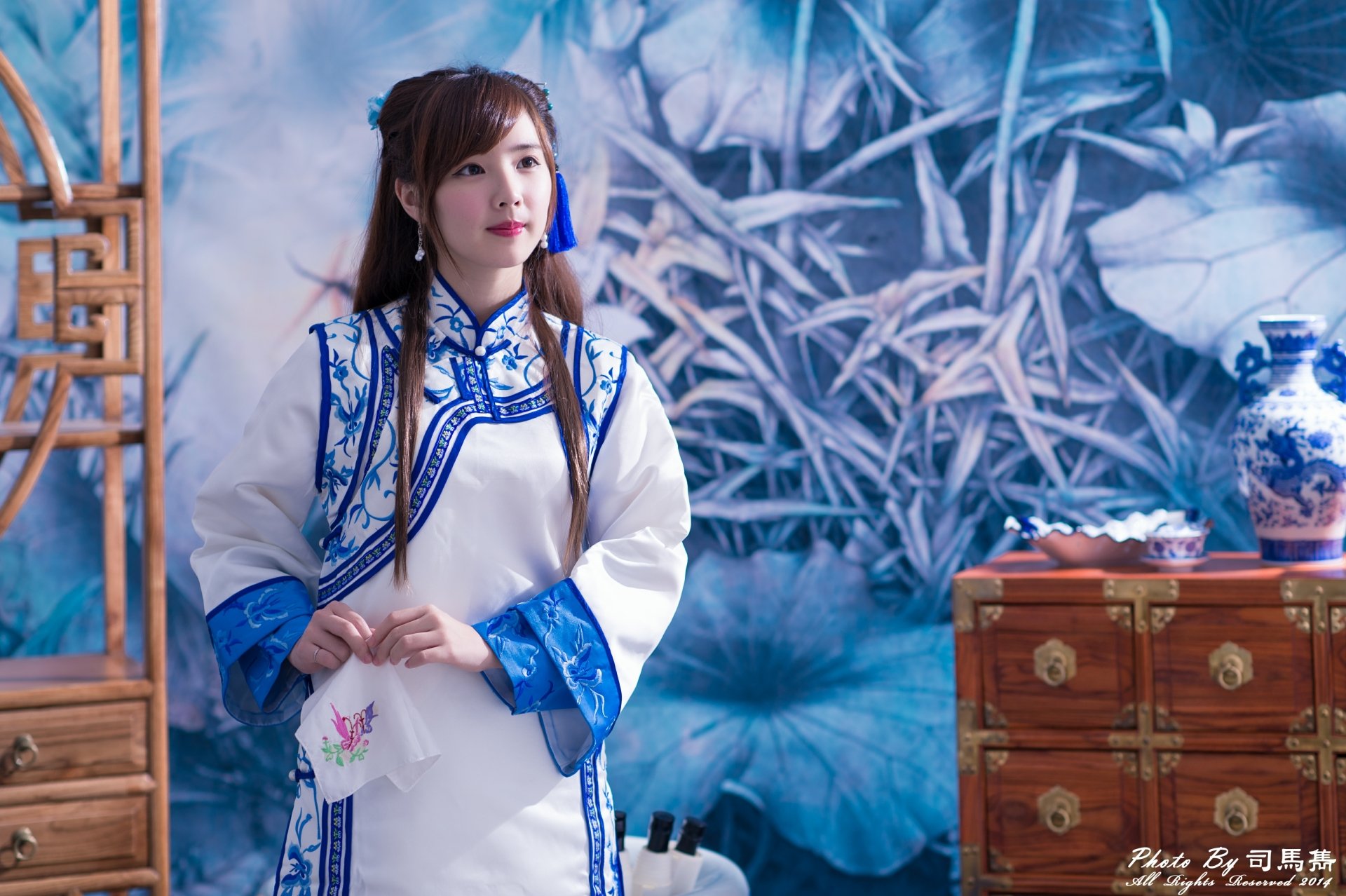 A Taiwanese woman model, Yu Chen Zheng, dressed in traditional costume poses beside a tea set and vase, captured in vibrant 4K Ultra HD for a desktop wallpaper.