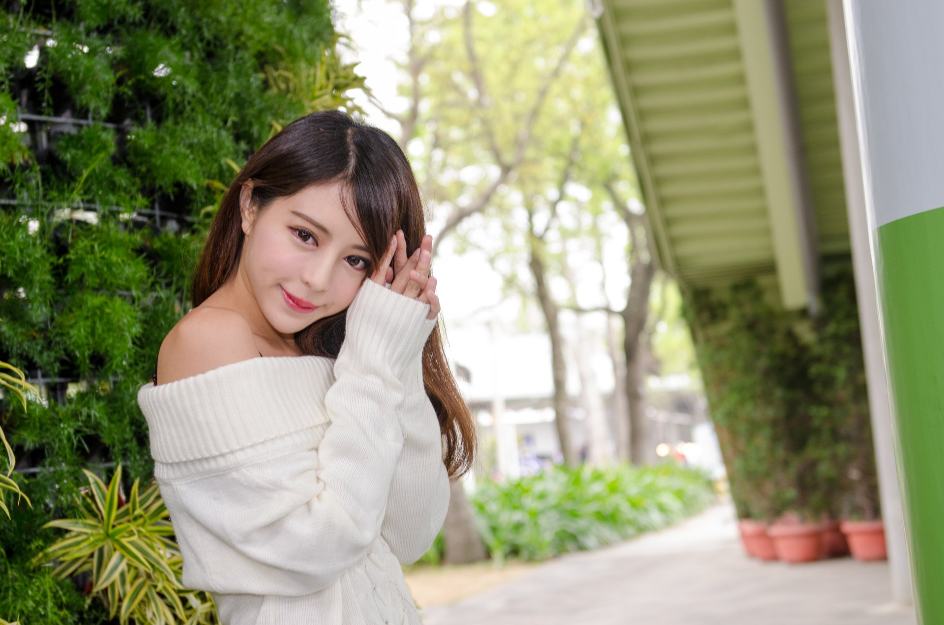A Taiwanese Asian model, Julie Chang (Zhang Qi Jun), smiles gently outdoors in a cozy white sweater, captured in stunning 4K Ultra HD for a PC desktop wallpaper.