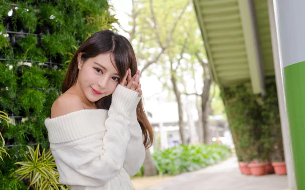 A Taiwanese Asian model, Julie Chang (Zhang Qi Jun), smiles gently outdoors in a cozy white sweater, captured in stunning 4K Ultra HD for a PC desktop wallpaper.