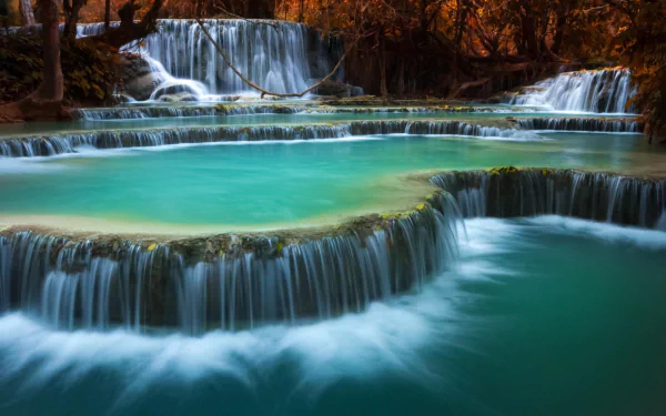 A serene view of Erawan Waterfall in Erawan National Park, Thailand, featuring cascading waters over natural turquoise pools, showcasing the beauty of nature.