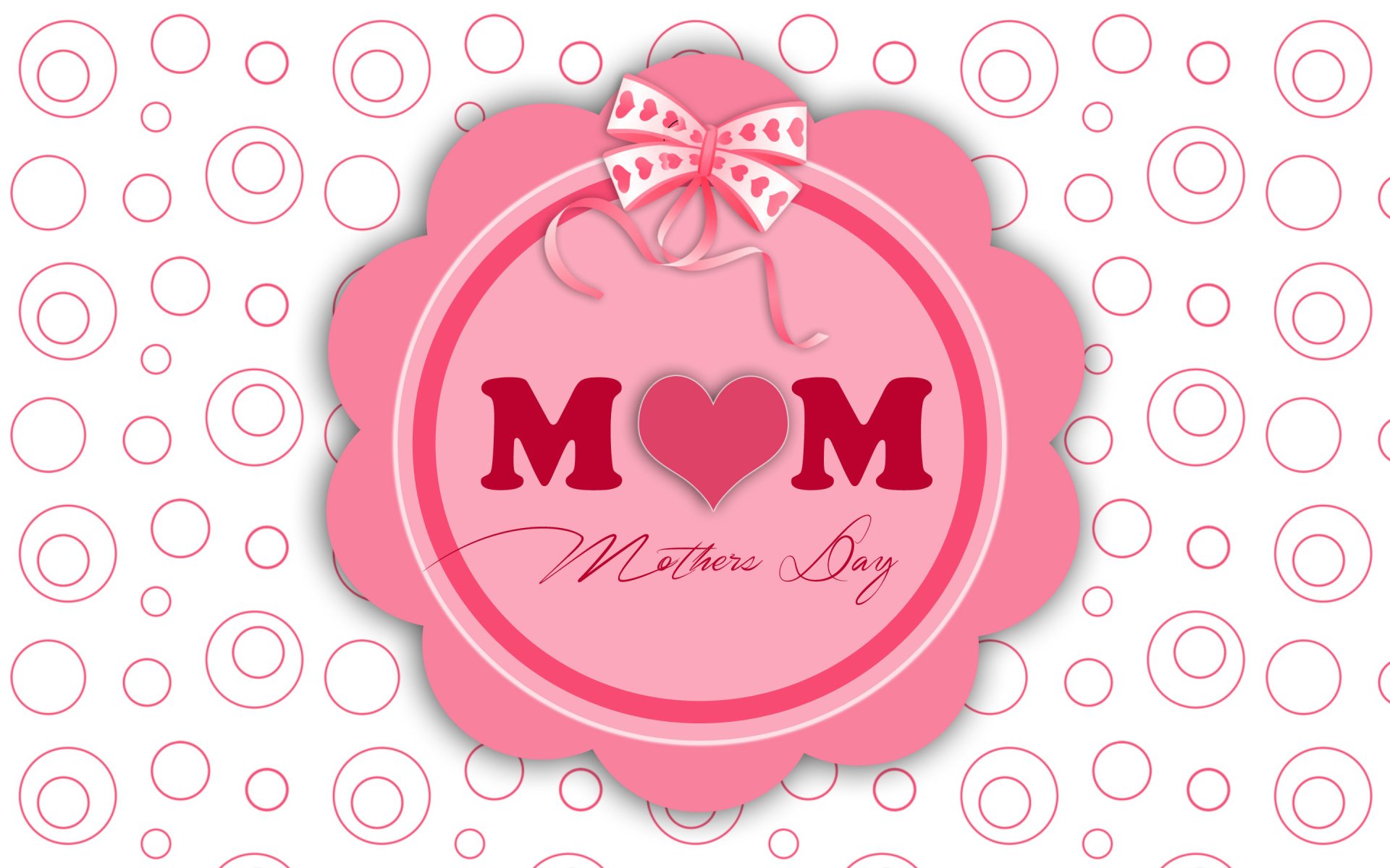 HD desktop wallpaper featuring a pink Mother's Day emblem with a heart replacing the O in MOM, set against a white background with pink circular patterns.