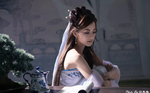 A Taiwanese woman with ornate hairpin and earrings sits beside a bonsai and traditional tea set, captured in a serene 4K Ultra HD wallpaper scene.