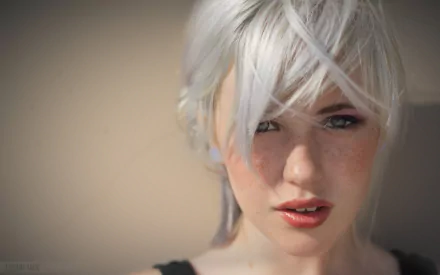 A captivating HD desktop wallpaper featuring a woman with white hair and freckles, embodying a striking model look. The backdrop enhances her unique beauty in a soft focus.