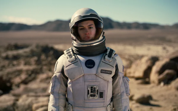 HD PC desktop wallpaper featuring a scene from the movie Interstellar with an astronaut in a spacesuit standing in a rocky, desert-like landscape.