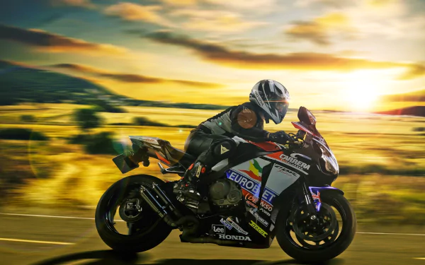 A racer on a Honda CBR motorcycle speeds across a scenic landscape during sunset, captured in stunning 4K Ultra HD for a vibrant PC desktop wallpaper.