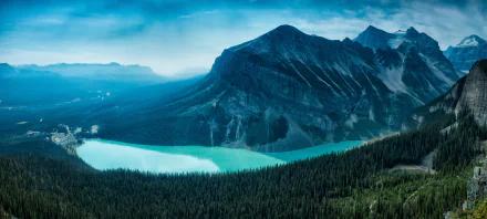 A breathtaking view of Lake Louise, nestled in Banff National Park, Alberta, surrounded by the stunning Canadian Rockies. The serene turquoise waters reflect the majestic mountains and lush forests.