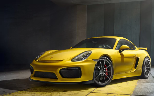 A striking yellow Porsche Cayman GT4 is showcased in this HD desktop wallpaper, highlighting its sleek design and powerful presence.