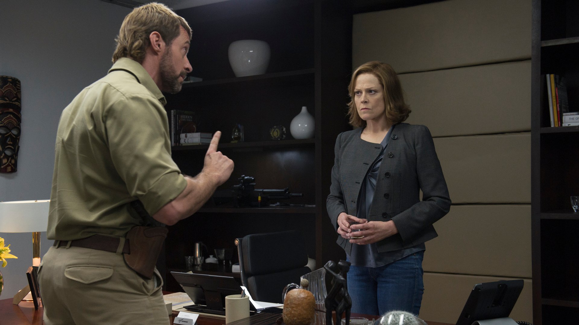 Hugh Jackman and Sigourney Weaver as Vincent Moore and Michelle Bradley in a tense scene from the movie Chappie, shown in 4K Ultra HD wallpaper quality.