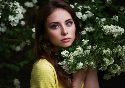 HD desktop wallpaper featuring brunette model Nadya Ryzhevolosaya with blue eyes surrounded by white flowers, blending natural beauty and serene floral elements.