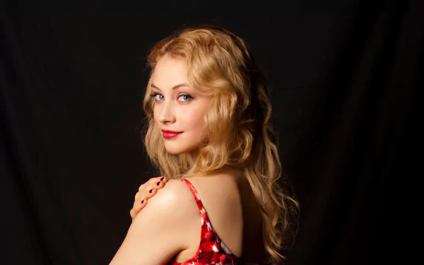 Portrait of Canadian actress Sarah Gadon with blue eyes and blonde hair against a dark background, captured in high-definition quality.