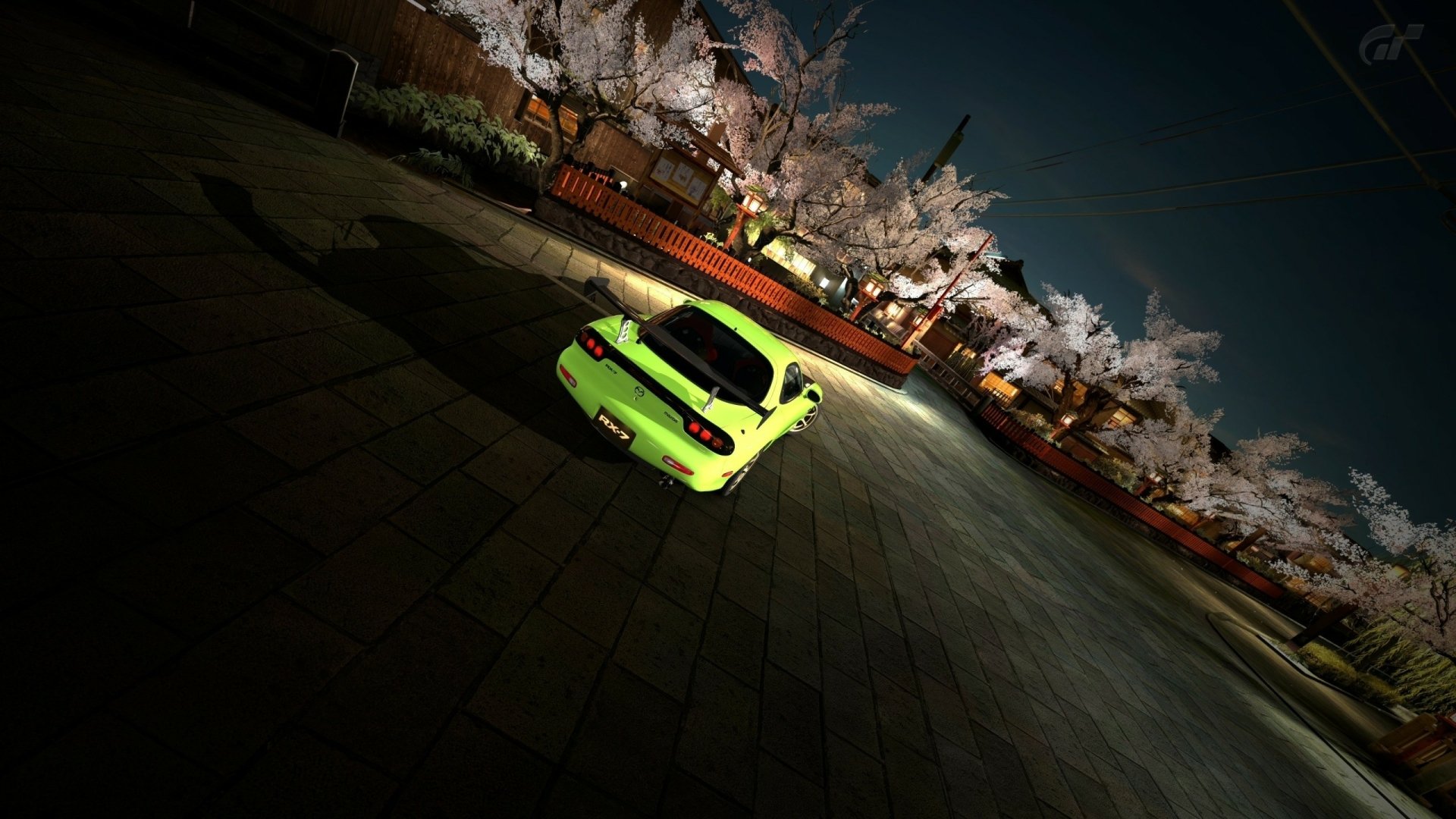 HD desktop wallpaper from Gran Turismo 5 featuring a vibrant green sports car under the glow of night-time cherry blossoms.