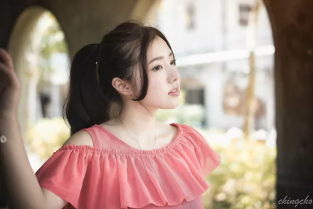 A beautiful Taiwanese model, Chén Sīyǐng, gazes thoughtfully in a soft-focus background, showcasing her serene expression and stylish pink outfit.
