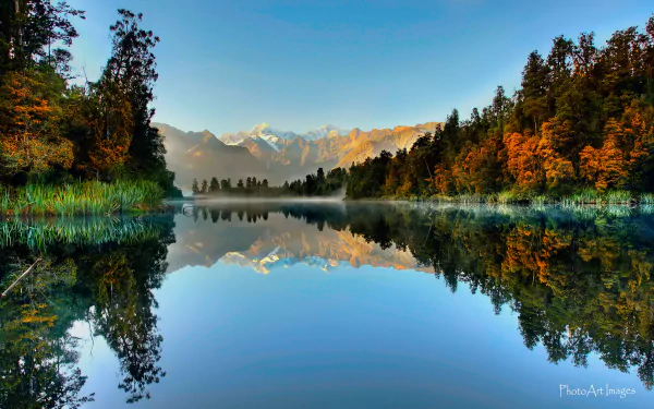 A serene autumn landscape reflecting the Southern Alps and Aoraki/Mount Cook in Lake Matheson, South Island, New Zealand, capturing the beauty of nature in vibrant fall colors.