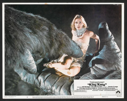 HD PC desktop wallpaper featuring a scene from the 1976 movie King Kong with the giant gorilla holding a woman in its hand against a dark background.