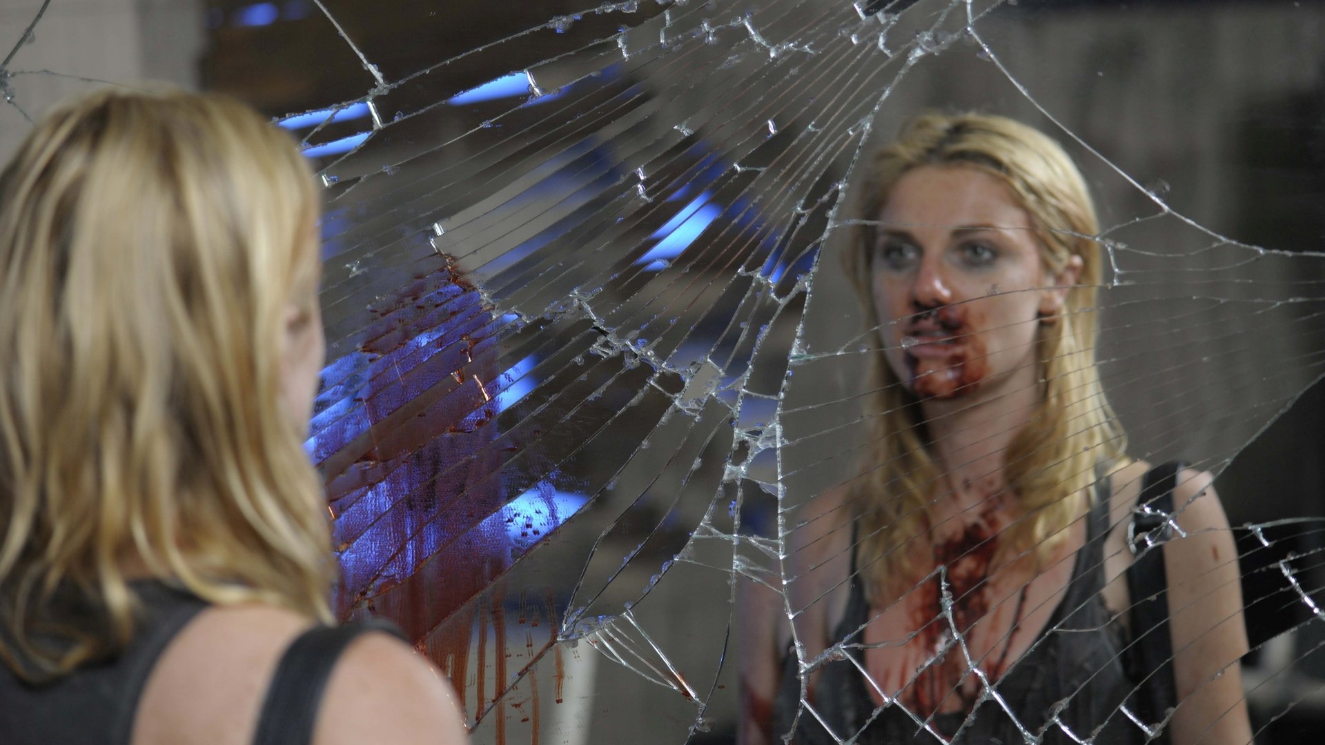 Movie-style 5K Ultra HD PC desktop wallpaper: a bloodied woman stares into a cracked mirror, reflection fractured by shattered glass, smeared blood and tense SX tape imagery.