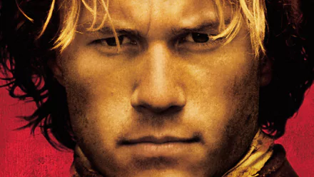 HD desktop wallpaper close-up of a stern blond medieval knight with a dirt-smudged face and intense gaze against a red backdrop; promotional image for the movie A Knight's Tale.