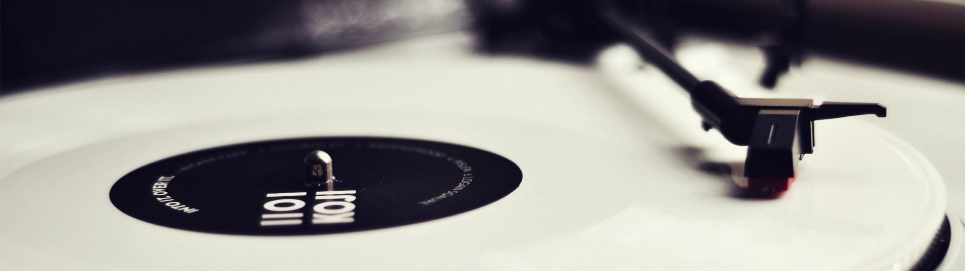 Close-up of a vintage phonograph record and stylus on a white turntable, minimalist music-themed HD PC desktop wallpaper and background.