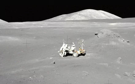 HD PC desktop wallpaper of a NASA moon landing: astronauts and a lunar rover on the cratered surface beneath a distant horizon, highlighting man-made exploration of the Moon.