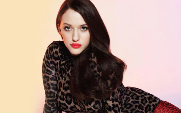 HD desktop wallpaper featuring celebrity Kat Dennings in a leopard print outfit against a soft gradient background.