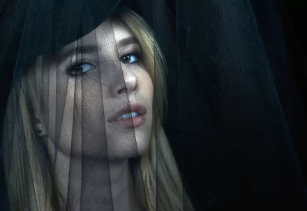 Close-up of Emma Roberts from American Horror Story, featuring her captivating gaze through sheer fabric, creating an intriguing and dramatic atmosphere for a HD desktop wallpaper.