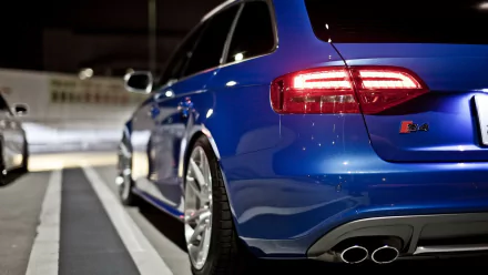 A blue Audi S4 parked by a curb, captured in high definition as a PC desktop wallpaper featuring the vehicle’s rear and side details.