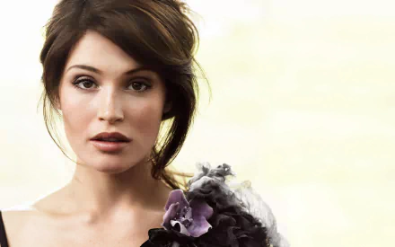 A close-up of brunette actress Gemma Arterton, showcasing her striking features and elegant style against a soft, light background. This HD image serves as a stylish desktop wallpaper.