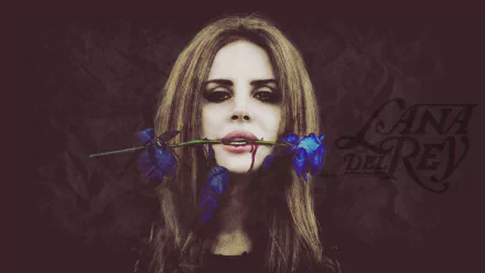 An HD desktop wallpaper featuring Lana Del Rey, with her holding a blue flower in her mouth, exuding a moody and artistic vibe. The background adds to the overall aesthetic of the image.