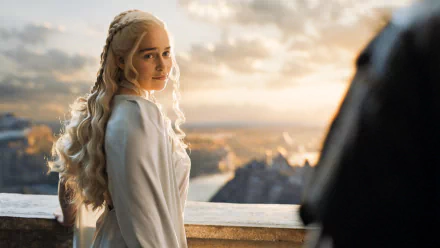 HD desktop wallpaper featuring Daenerys Targaryen, portrayed by Emilia Clarke in the TV show Game of Thrones. She stands with a serene expression, with a picturesque landscape in the background.