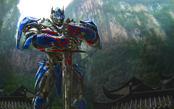 HD desktop wallpaper featuring Optimus Prime from the Transformers movie, standing heroically with a sword against a backdrop of lush mountains and traditional rooftops.