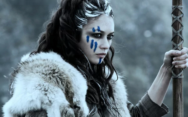 HD desktop wallpaper featuring Olga Kurylenko as a warrior with blue face paint in the movie Centurion, dressed in fur and gripping a staff.