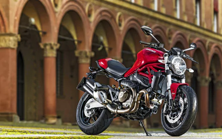 Red Ducati Monster 821 motorcycle in front of an arched brick colonnade — vehicle photo as a 2K Quad HD PC desktop wallpaper and background.
