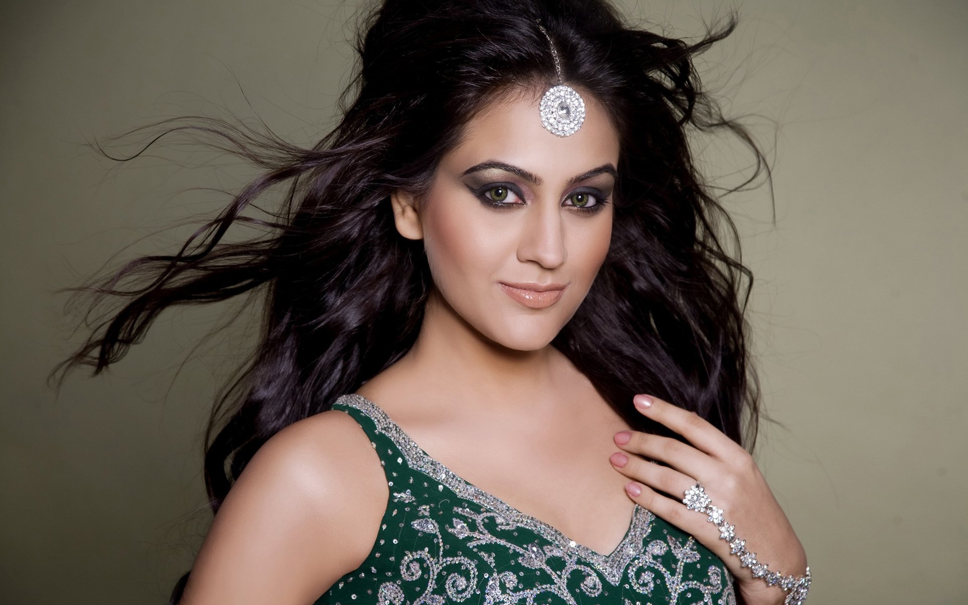 HD desktop wallpaper of Aksha Pardasany, an Indian actress with green eyes, black hair, and a traditional outfit, posing confidently against a neutral background.