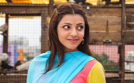 Kajal Aggarwal shines in this vibrant HD wallpaper from the movie Maari, showcasing her charming smile and colorful attire against a rustic backdrop.